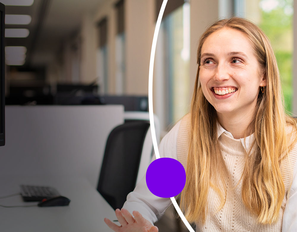 Smiling woman sitting at a desk in an office.
