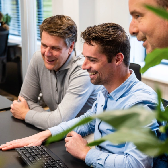 Lachende Kenonz collega aan het werk onder toeziend oog van collega's.