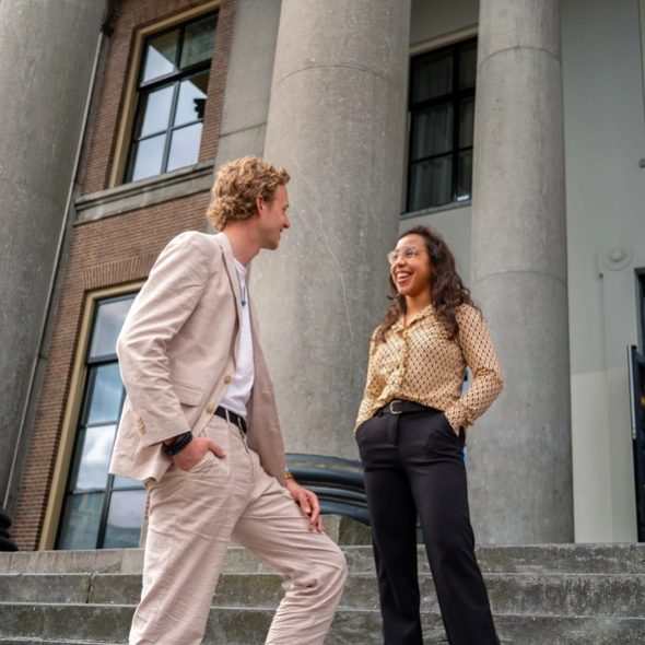 Twee Kenonz collega's staan voor een gemeentehuis.