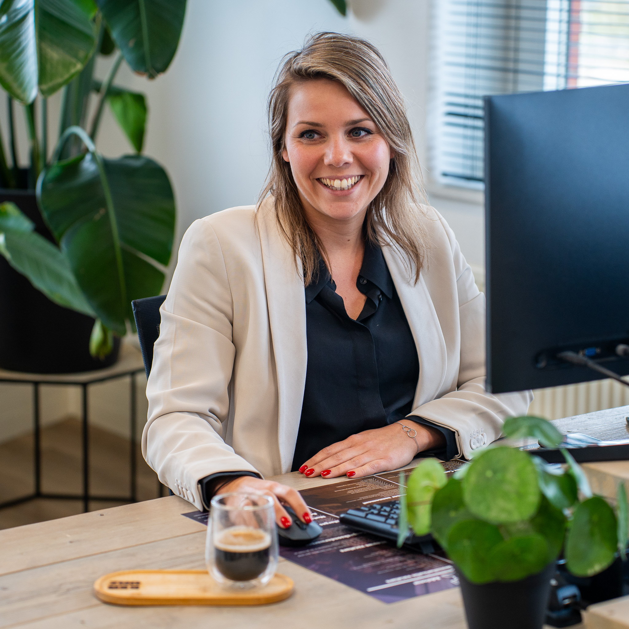 Kenonz collega achter computer met kop koffie.