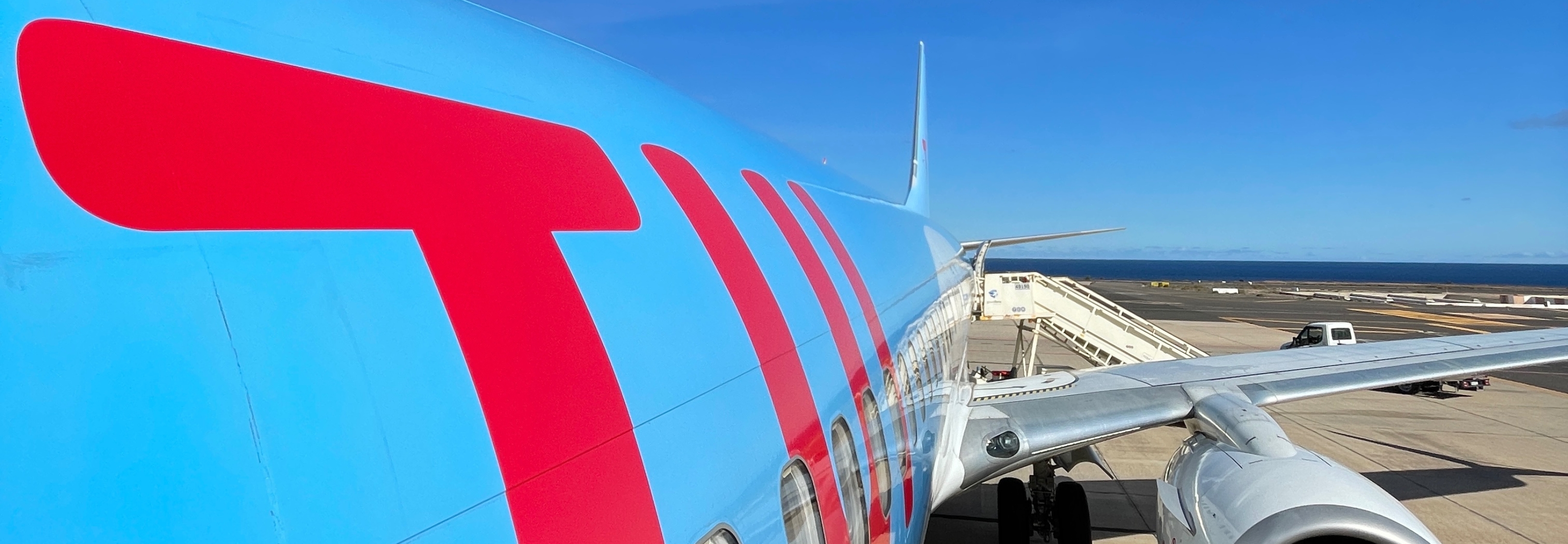 A TUI aircraft sits in front of a blue sky