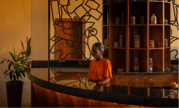 A colleague welcomes guests with a smile at The Mora reception desk