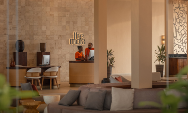 Two colleagues stand talking at a desk in The Mora reception