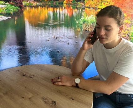 Junge Frau am Handy im Gespräch vertieft