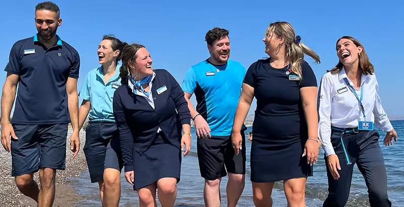 Group of people walking on the beach and laughing