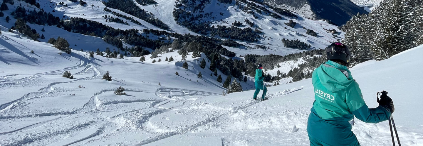 A Crystal Ski Rep in Crystal Ski uniform looks into the distance at a snowy landscape.