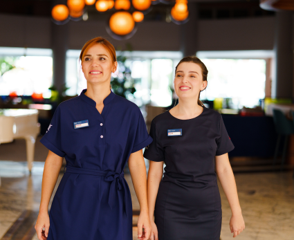 Two female TUI BLUE colleagues walk through a hotel reception together.