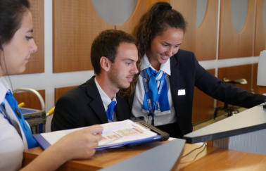 Three Intercruises colleagues look smiling over a laptop.