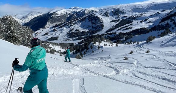 A Crystal Ski colleague stands with their back to the camera in a snowy mountain landscape