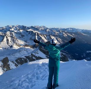 A Crystal Ski colleague stands with their back to the camera in a snowy mountain landscape