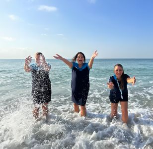 Three TUI colleagues stand splashing the sea in Turkey