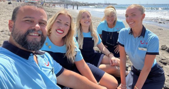 A group of TUI colleagues smile on a beach in Tenerife