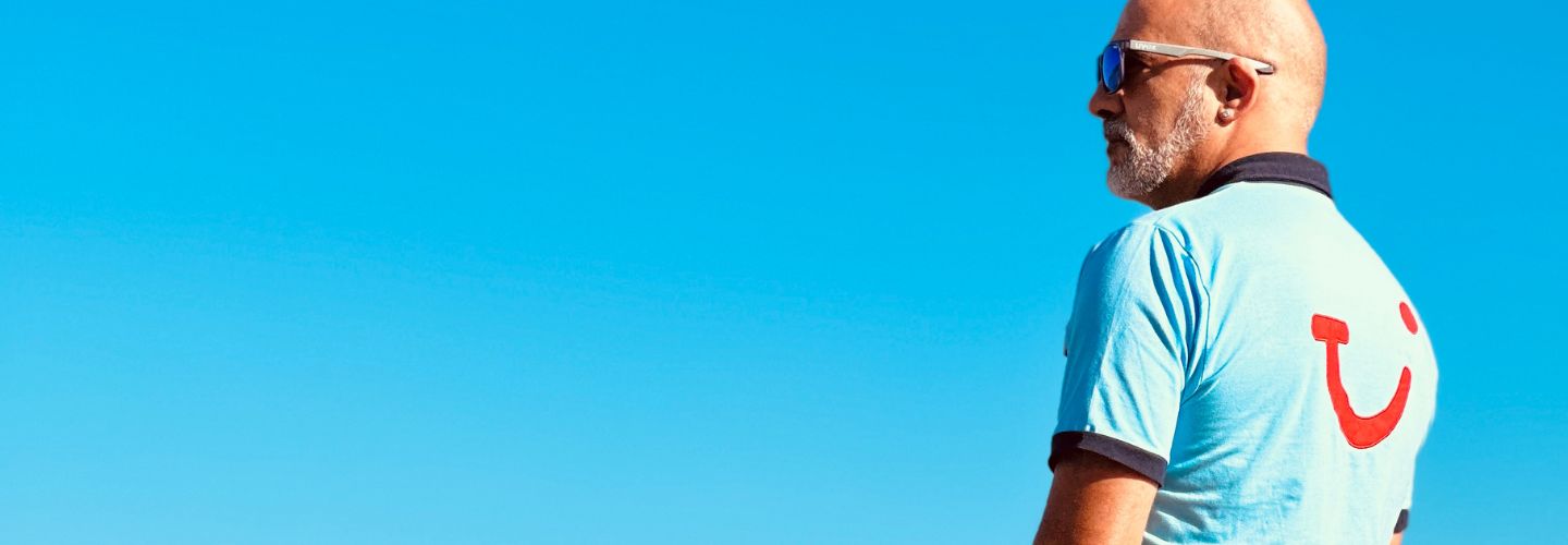 A TUI Rep stands in front of a blue sky