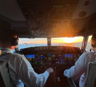 Two pilots on the runway ready to take of into a very beautiful sunrise