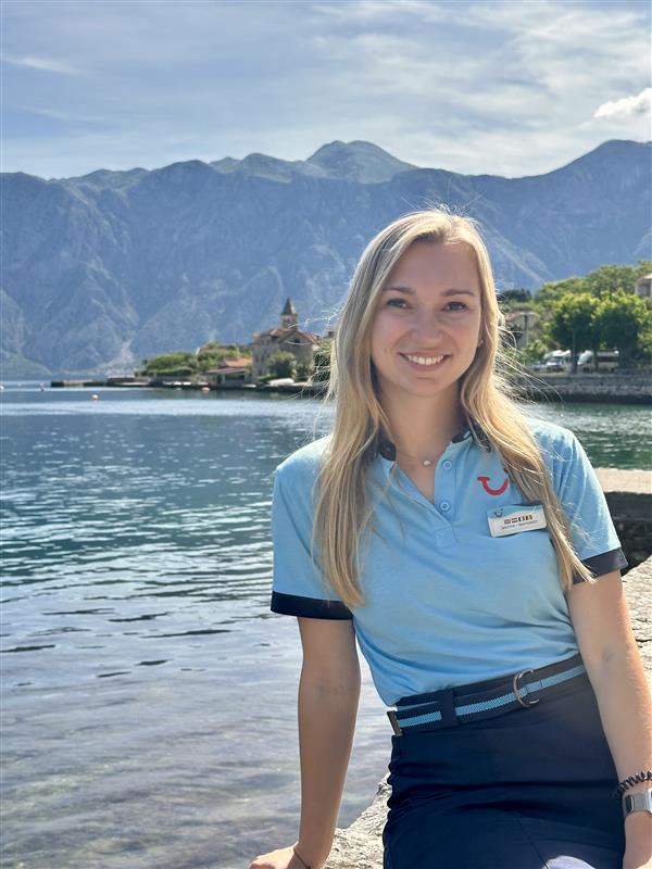 female colleague with a TUI Rep uniform standing in front of a lake