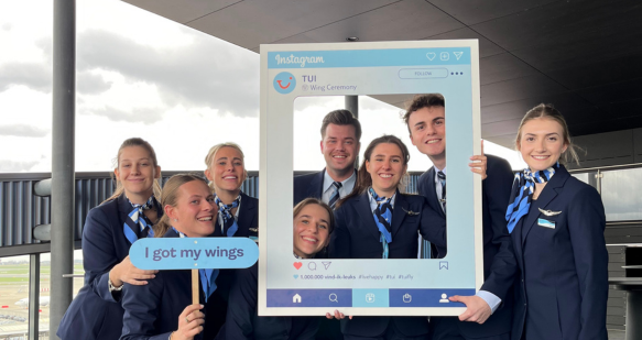 Smiling cabin crew posing with their wings 