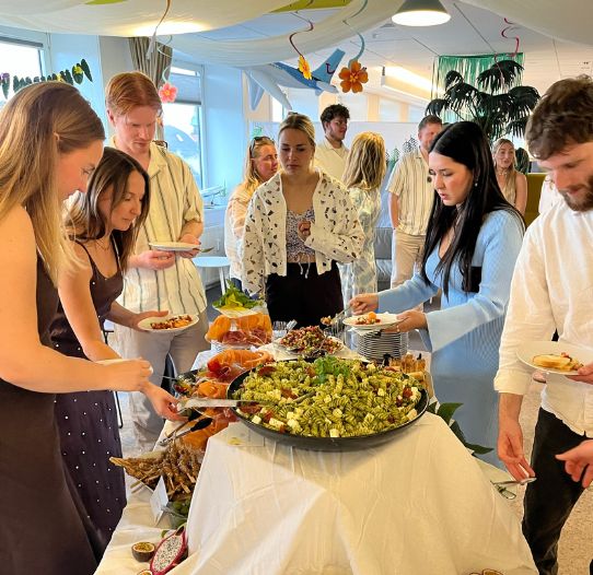 A group of TUI Denmark colleagues stand at a social gathering in the office