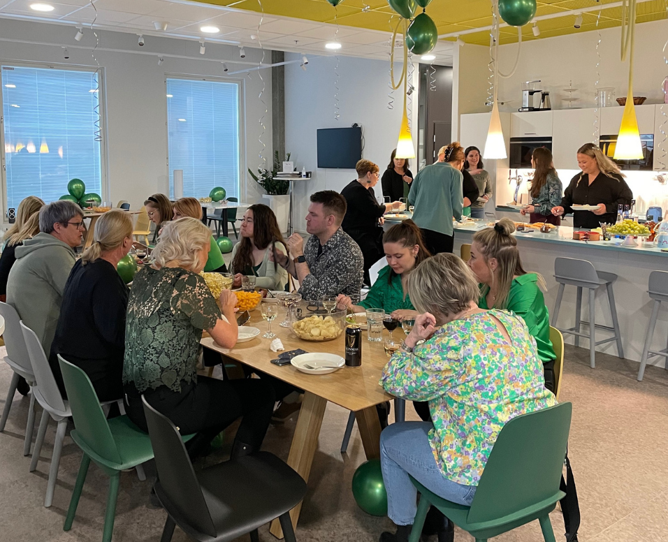 Group of people socialising in a kitchen at the TUI office.