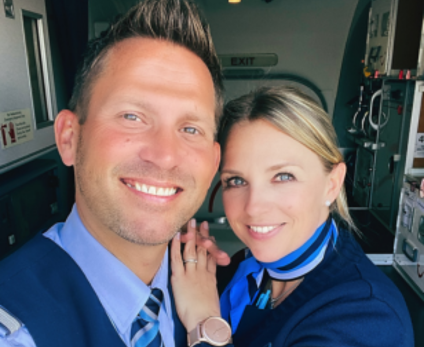 A female and a male flight attendant take selfie in the gally of a TUI airplane