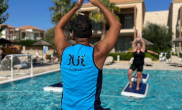 A TUI BLUE Entertainer carries out an Aquaboard class at the hotel pool