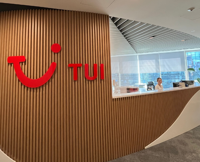A TUI Poland colleague stands at a reception desk smiling.