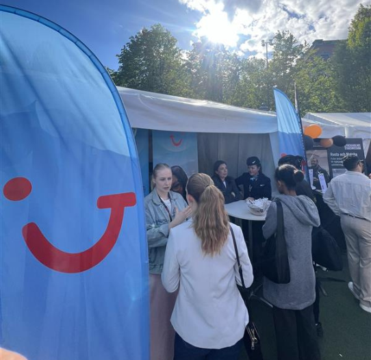 The TUI Sweden team attend an outdoor job event with a TUI flag
