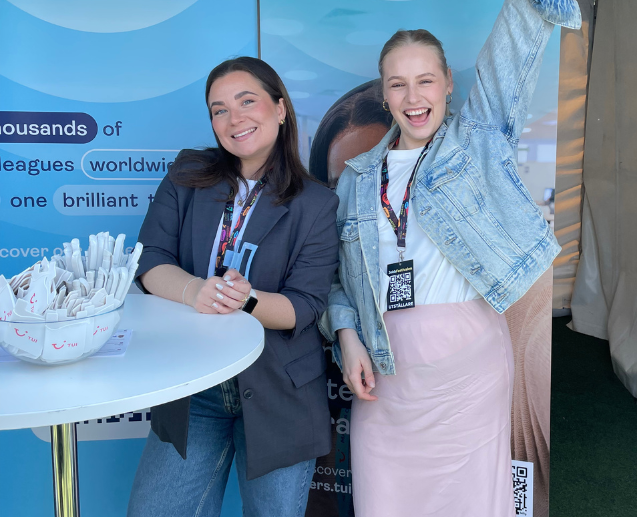 Two TUI Sweden colleagues smile at a TUI pop up at a job fair event.