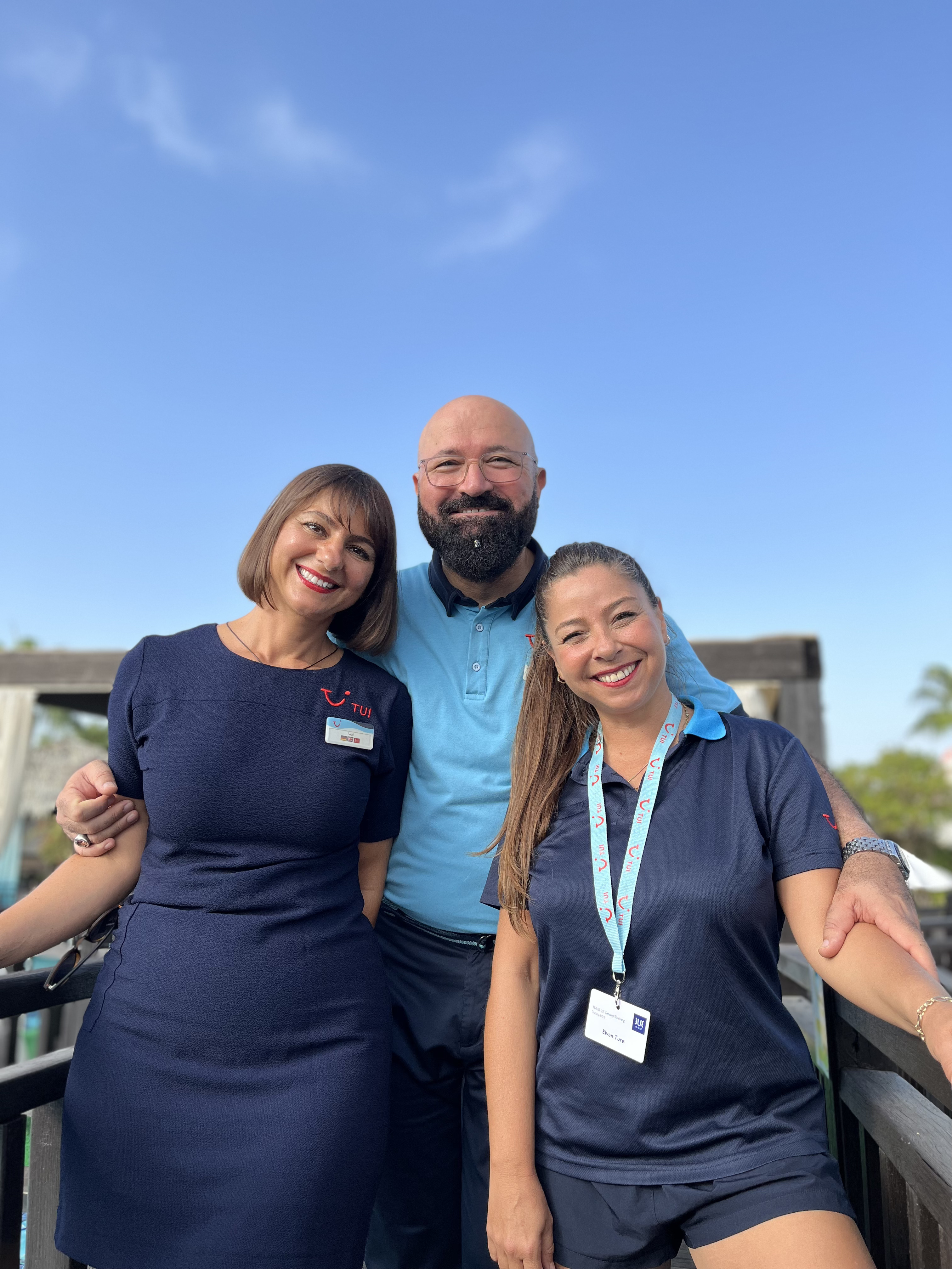 three TUI colleagues smiling at the camera