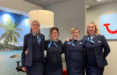 A group af four female travel agents smiling at the camera