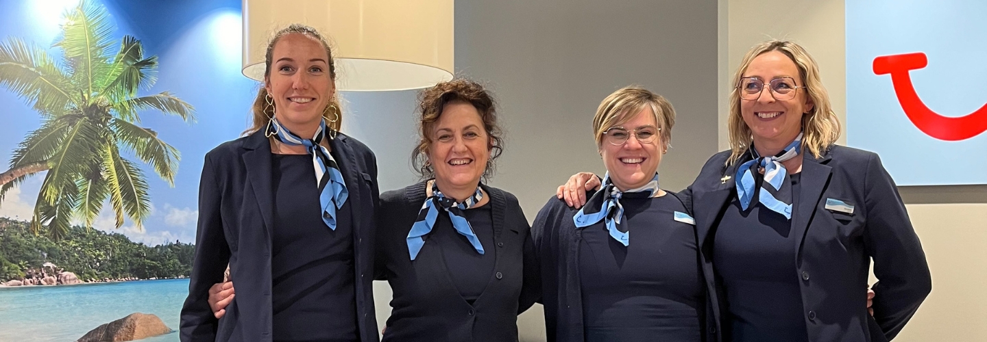 Four female travel agents smiling at the camera