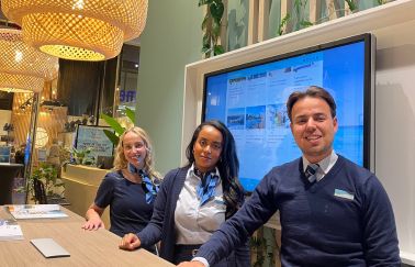 Two female and one male travel agent looking into the camera