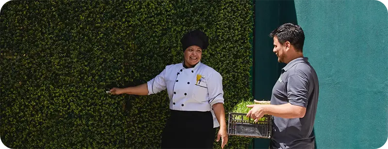 Two people talking outside in the sun.