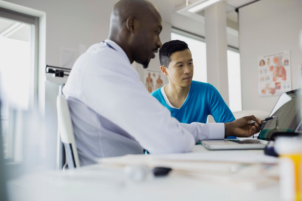 Doctor showing tablet to patient in clinic