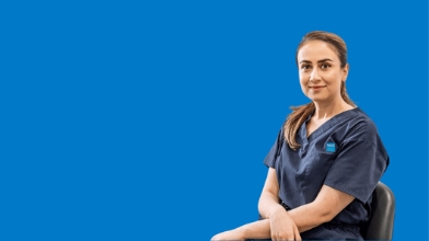 Healthcare professional seated against blue backdrop