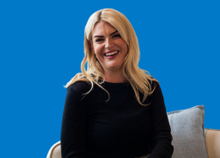 Person seated on chair against blue background wall