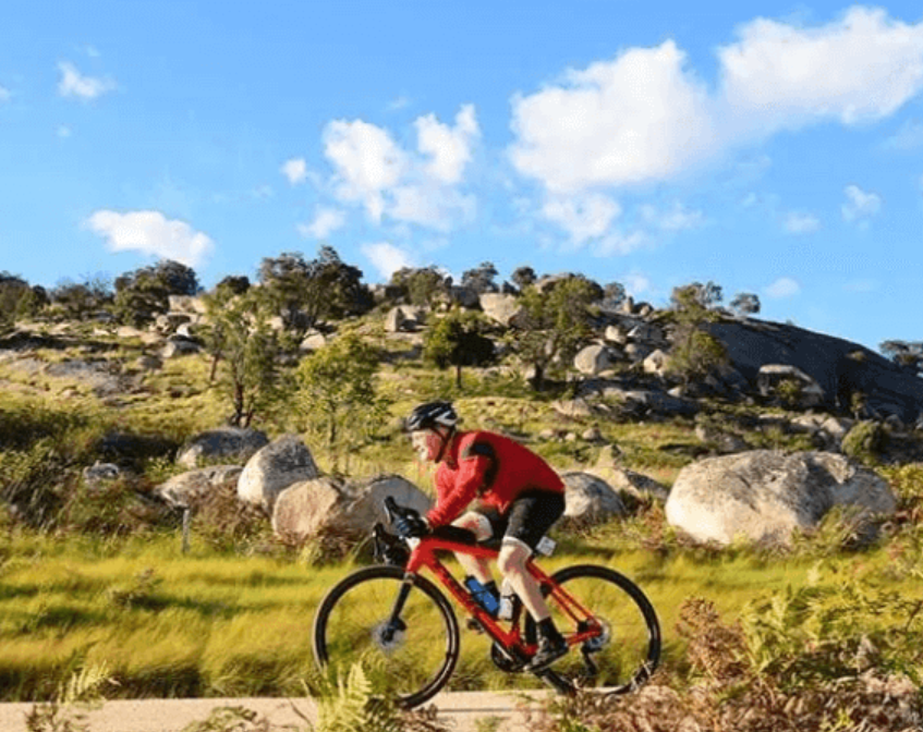 Cyclist riding scenic trail through rocky grassland