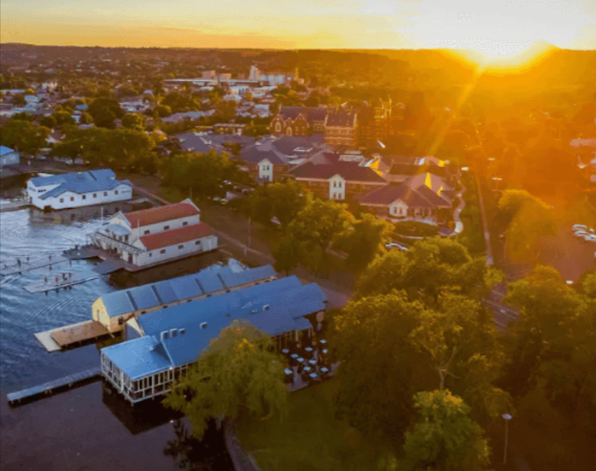 Aerial waterfront town view glowing at sunset sky