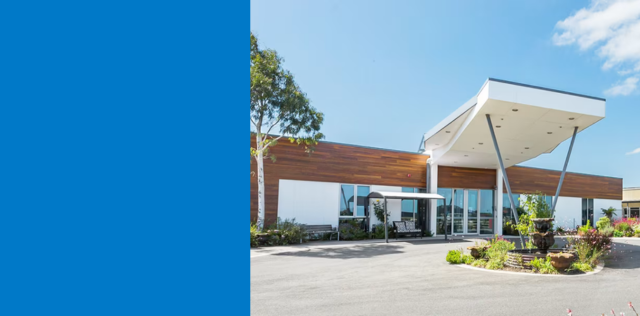 Modern building entrance with canopy and landscaping