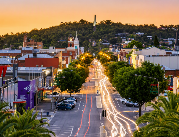 City street light trails at sunset, hillside town