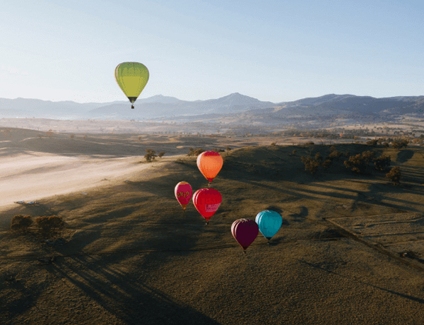 Hot air balloons over misty valley landscape