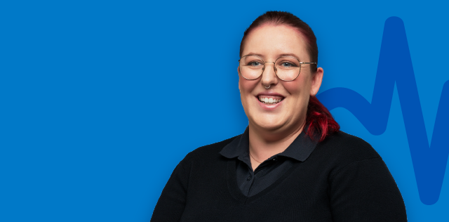 Person smiling in glasses on blue background