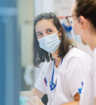 Two masked medical staff talking in clinic