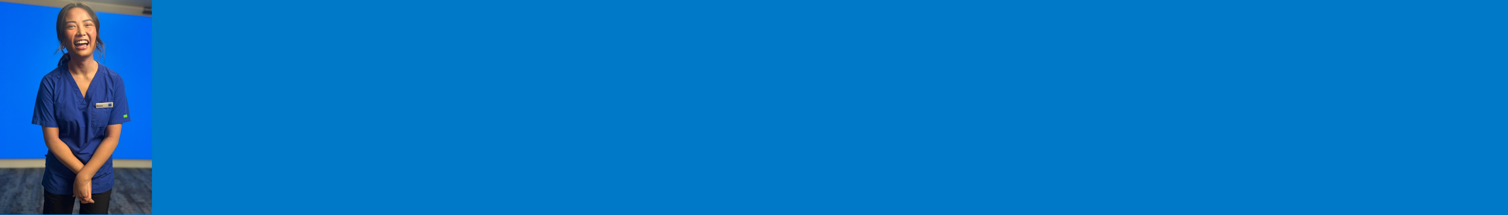 Healthcare worker in blue scrubs smiling