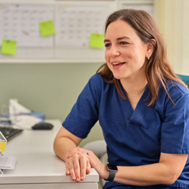 Person in scrubs talking in clinic office