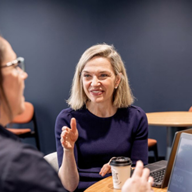Person gesturing while talking at meeting table