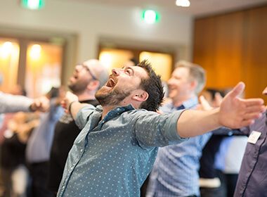 People celebrating enthusiastically at an indoor event