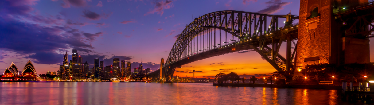 Sydney Harbour Bridge at sunset over city skyline