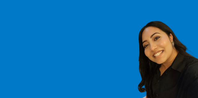 Person smiling in black top on blue background