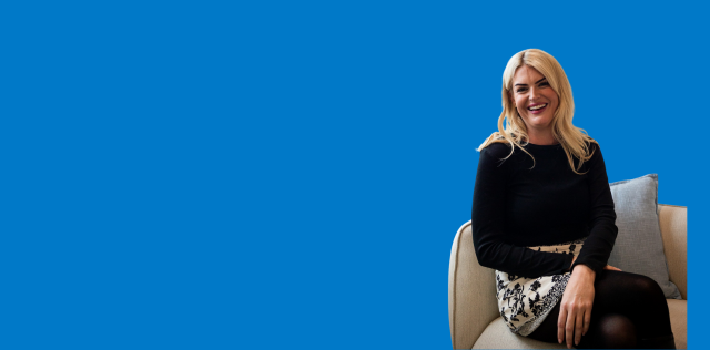 Person seated on chair against blue background wall