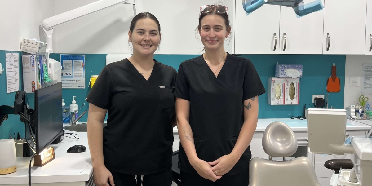 Two people in scrubs standing in dental clinic
